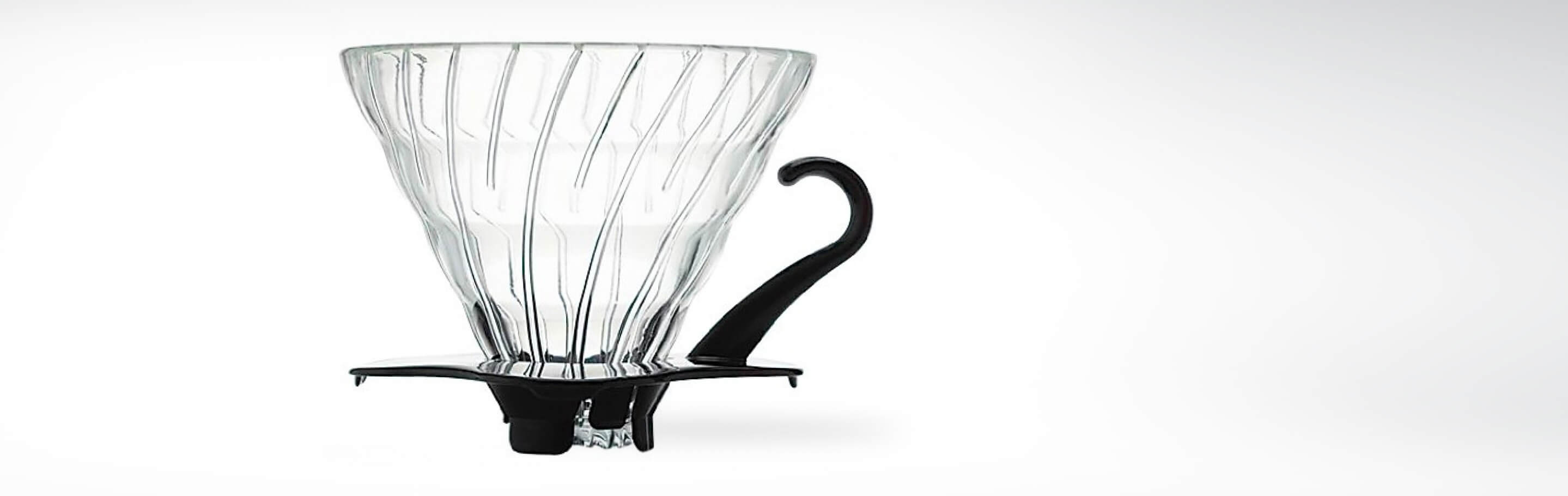 Ein transparenter Kaffeefilterhalter aus Glas mit einem schwarzen Griff