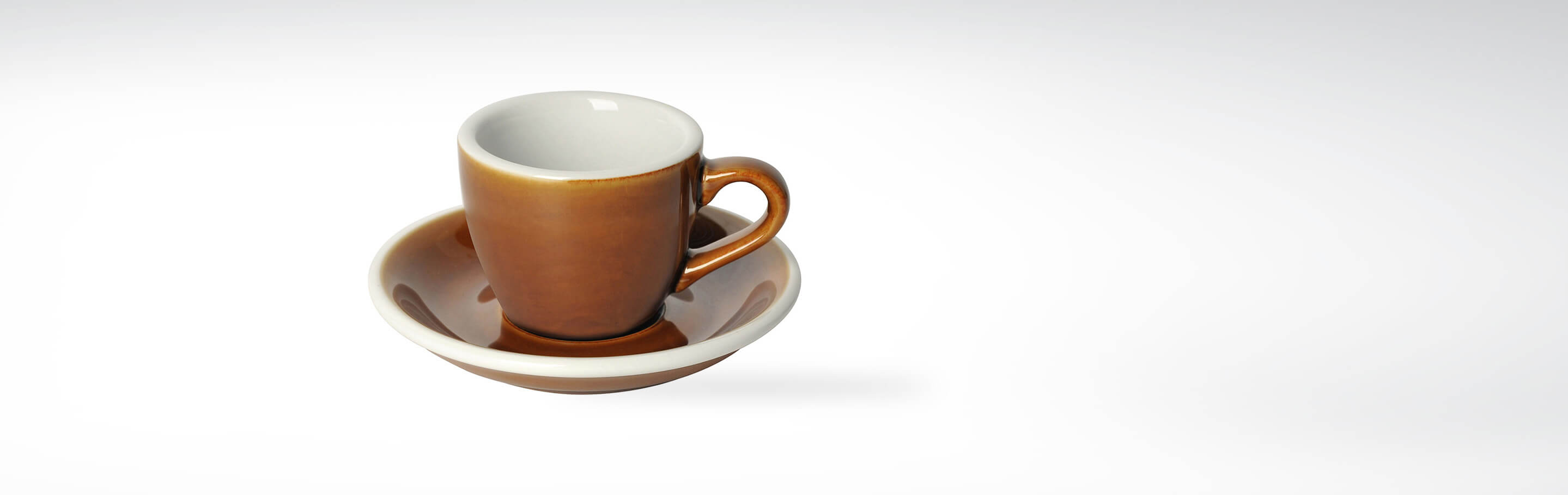 Braune Espressotasse mit dazugehöriger Untertasse aus Keramik, auf weißem Hintergrund