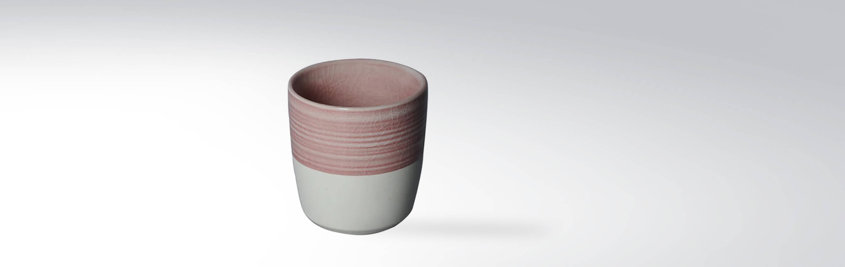 Keramikbecher mit rosa, texturiertem Rand auf weißem Hintergrund