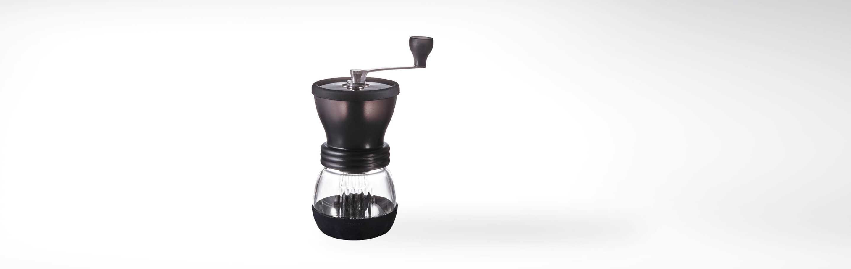 Manuelle Kaffeemühle mit Kurbel, schwarzem Oberteil und gläsernem Auffangbehälter