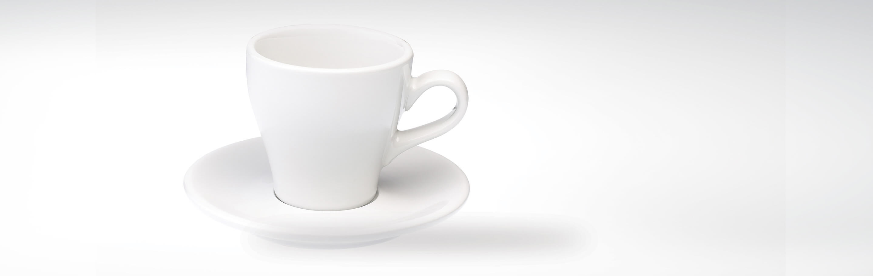 Weiße Porzellantasse auf Unterteller vor weißem Hintergrund