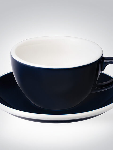 Eine elegante schwarze Teetasse mit passender Untertasse auf grauem Hintergrund, perfekt für stilvolle Kaffeemomente.