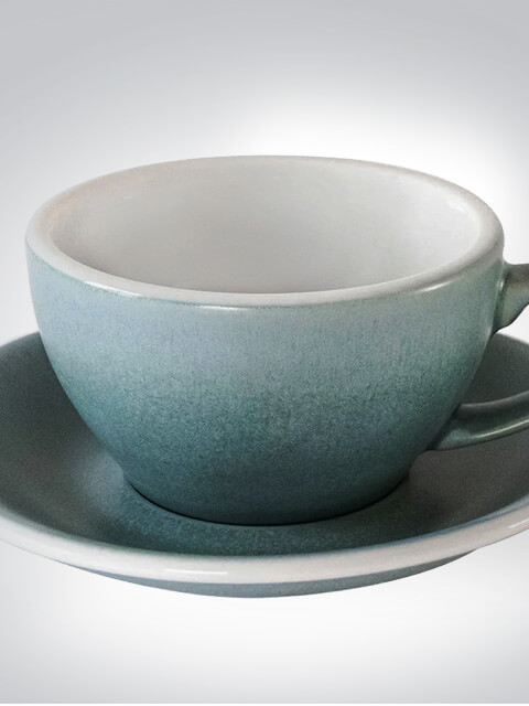 Graue Keramiktasse mit passender Untertasse auf einem neutralen Hintergrund