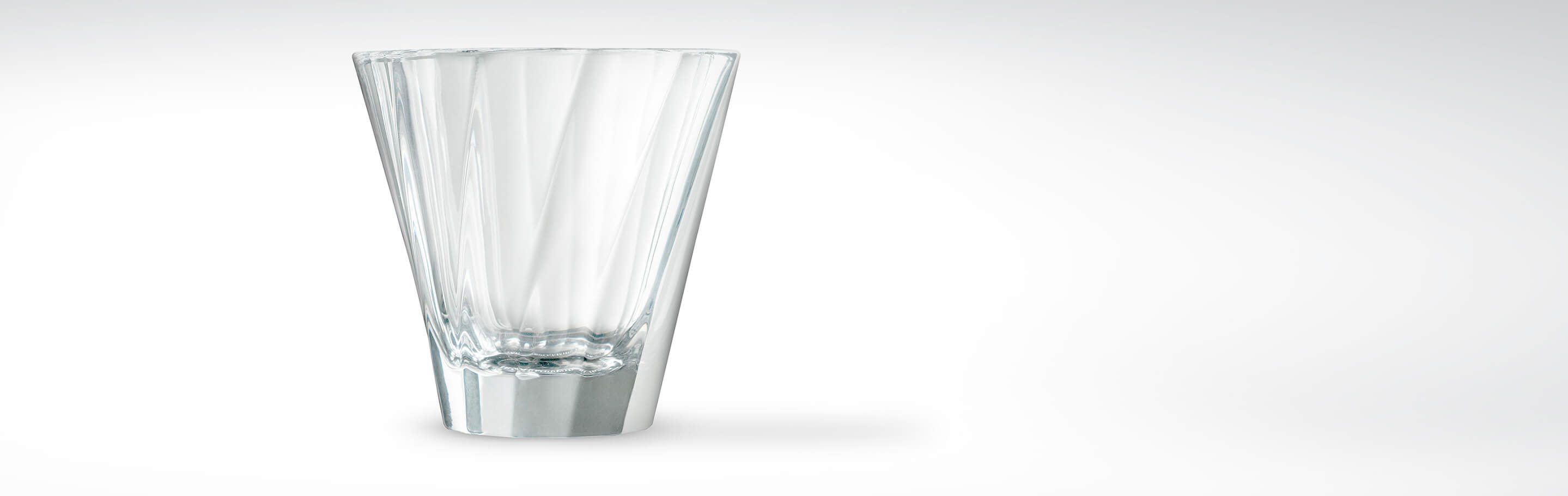 Hohes, konisch geformtes Trinkglas aus klarem Kristallglas auf weißem Hintergrund