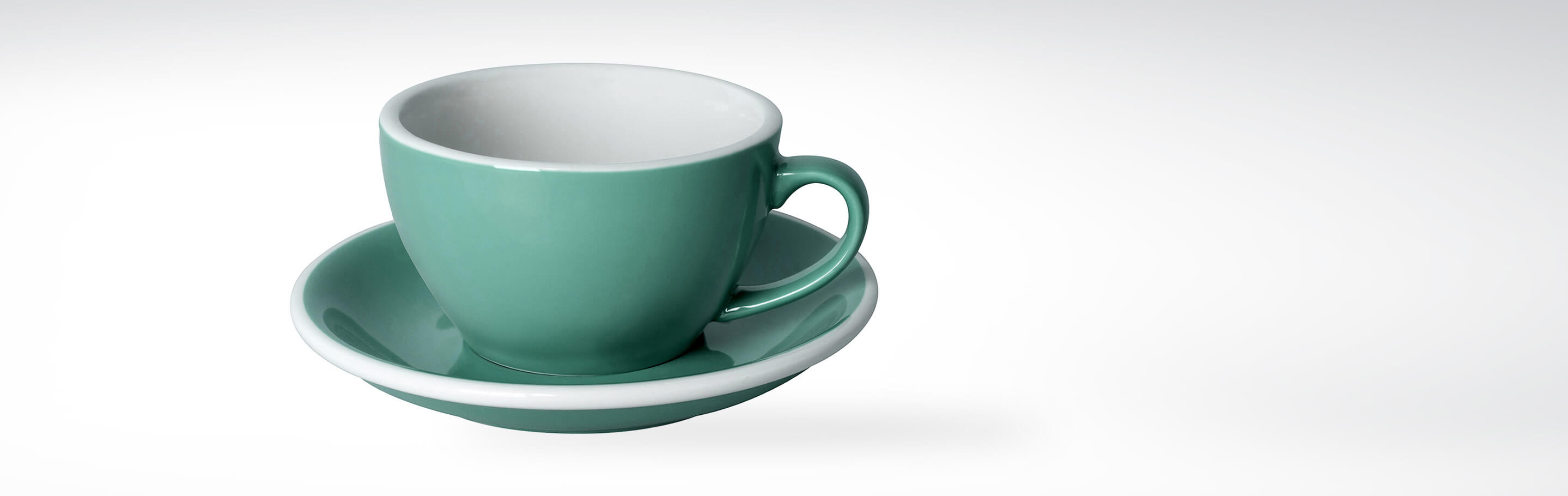 Grüne Keramiktasse mit passender Untertasse, ideal für Kaffee oder Tee