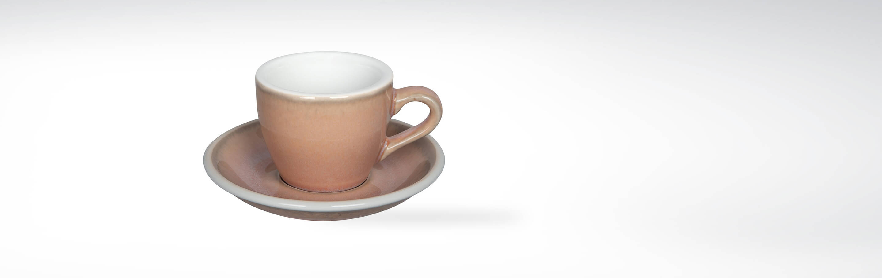 Keramik Espresso Tasse auf passender Untertasse in beige Farbton vor weißem Hintergrund