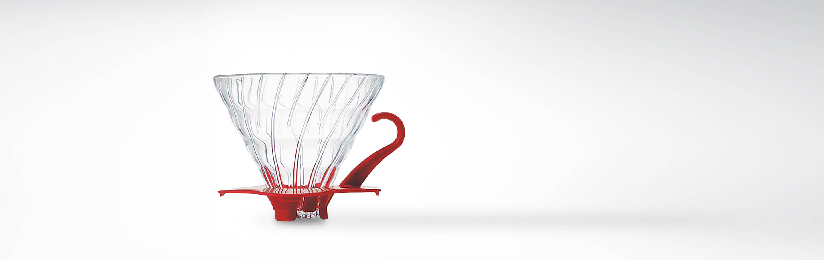 Kaffeetropfer aus Glas mit rotem Griff auf weißem Hintergrund