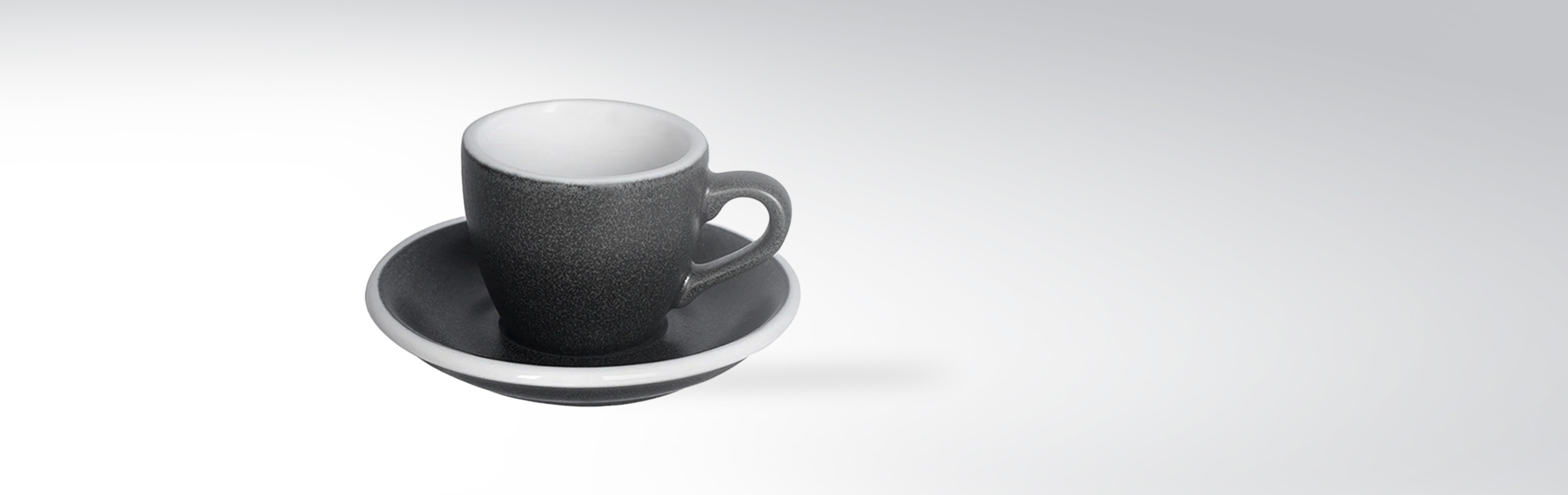 Elegante graue Espresso-Tasse mit passender Untertasse auf neutralem Hintergrund
