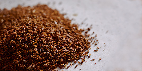 Haufen mit frisch gemahlenem Kaffeepulver auf einer Tischoberfläche