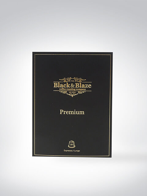 Schwarze Verpackung von Black & Blaze Kaffee mit goldener Beschriftung, Aufschrift Premium, für Espresso und Lungo geeignet