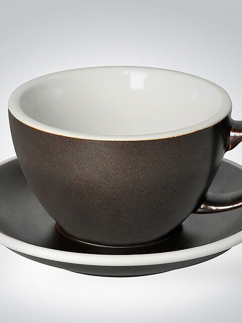 Nahaufnahme einer eleganten schwarzen Tasse mit weißem Inneren und passender Untertasse