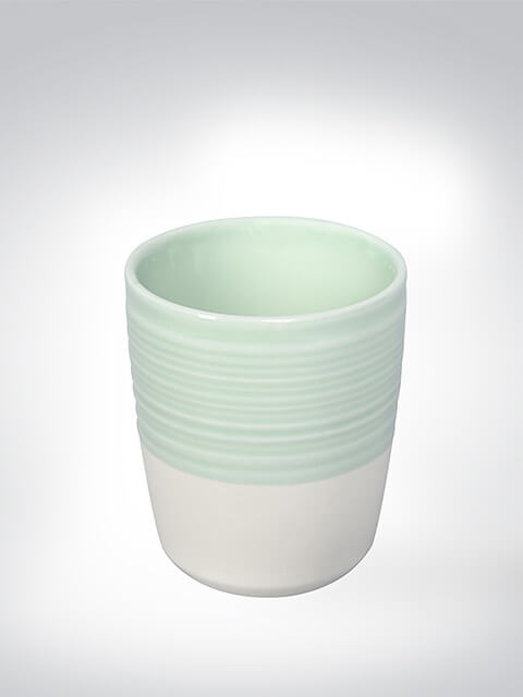 Keramikbecher in Pastellgrün mit strukturierter Oberfläche und glattem, weißem Unterteil