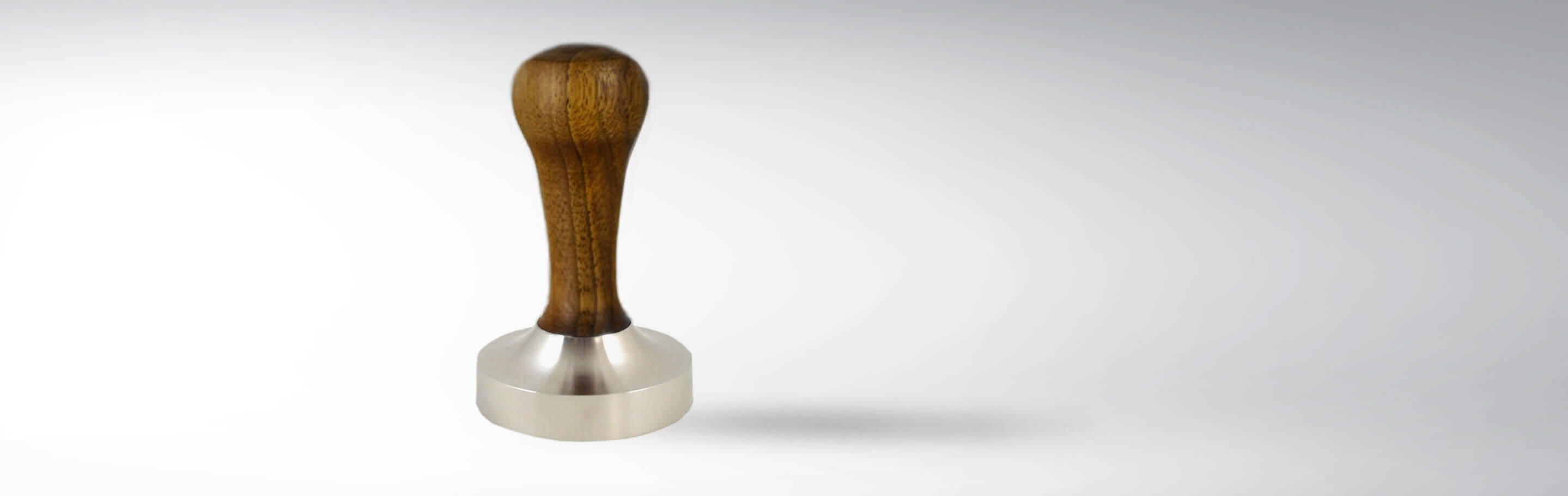 Espressostempel aus Edelstahl mit ergonomischem Holzgriff auf weißem Hintergrund