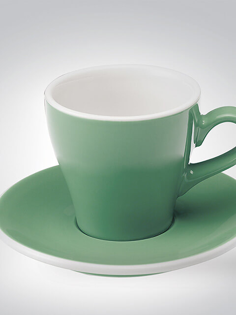 Grüne Porzellan-Teetasse mit passender Untertasse auf weißem Hintergrund