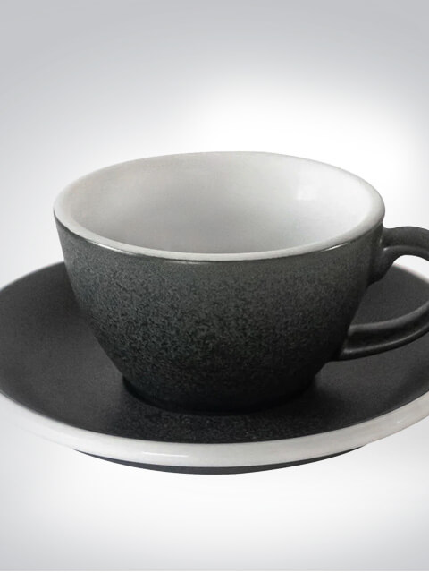 Schwarze Keramiktasse mit passender Untertasse auf weißem Hintergrund