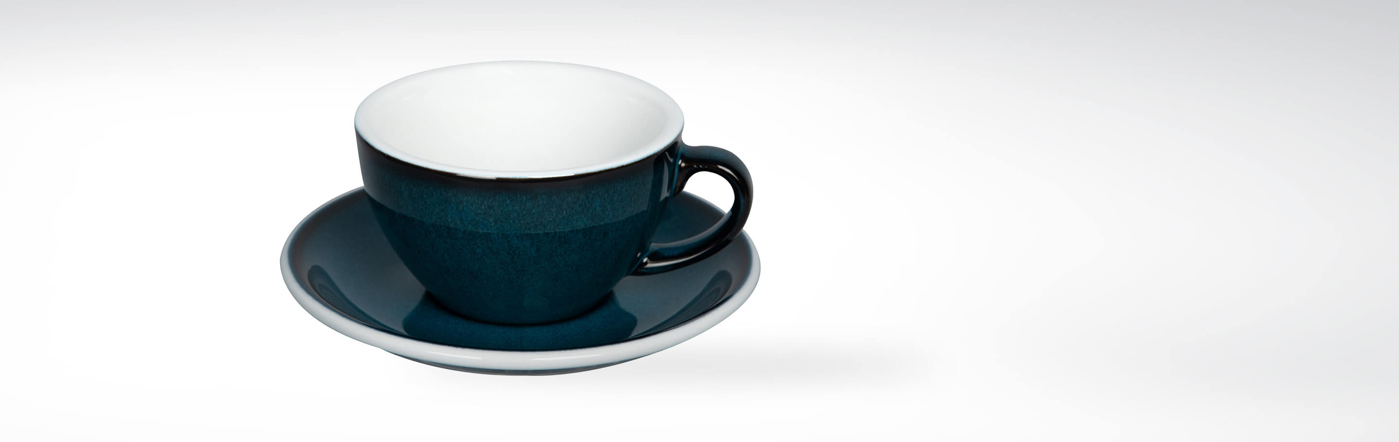 Eine dunkelblaue Kaffeetasse mit passender Untertasse auf weißem Hintergrund