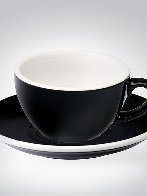Schwarze Teetasse mit Untertasse vor weißem Hintergrund
