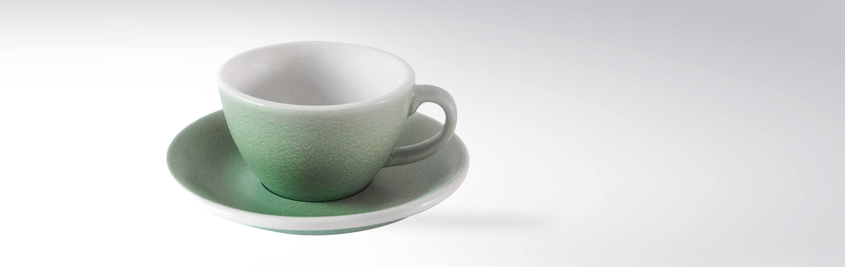 Eine elegante grüne Tasse mit passender Untertasse vor einem weißen Hintergrund