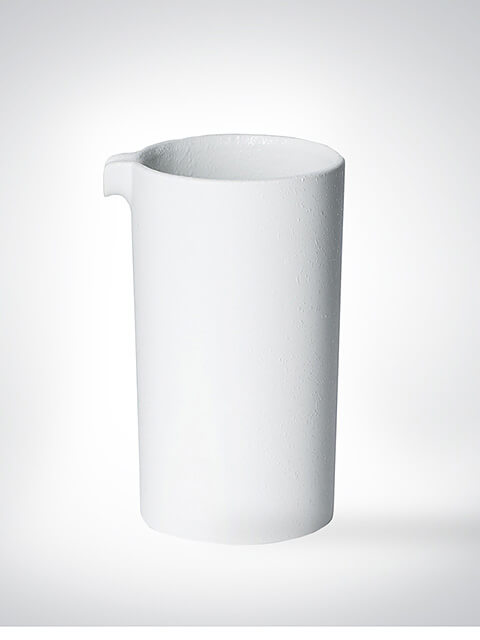 Ein schlichter, moderner Krug aus weißer Keramik mit kleinem Ausguss