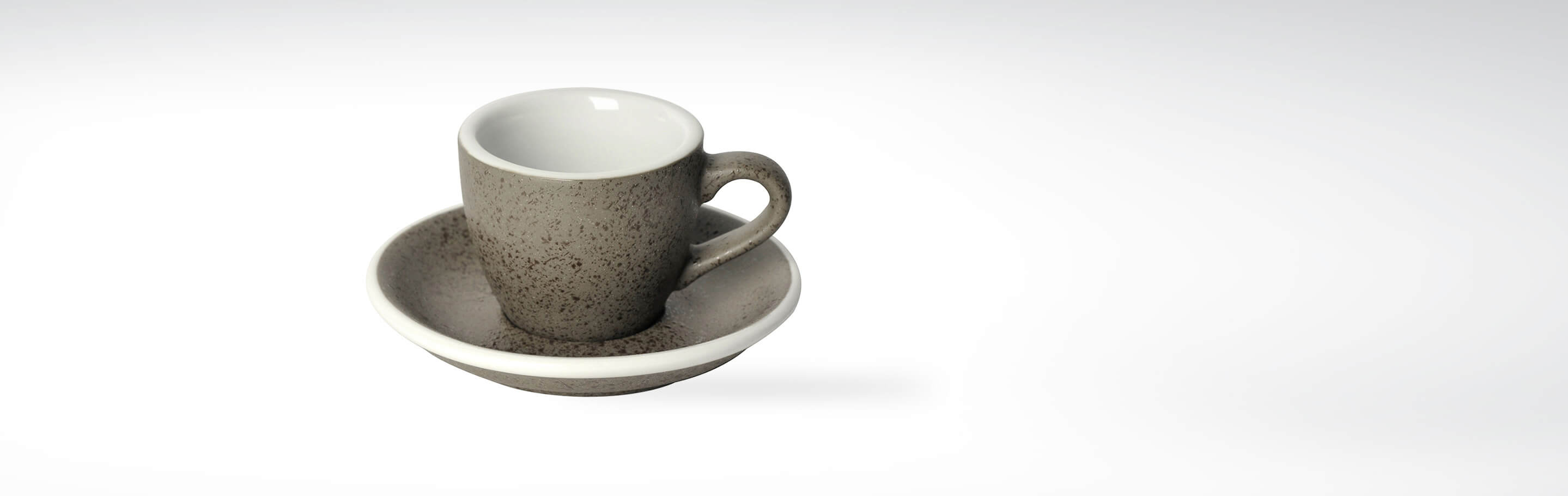 Steingraue Espressotasse mit passender Untertasse aus Keramik auf weißem Hintergrund