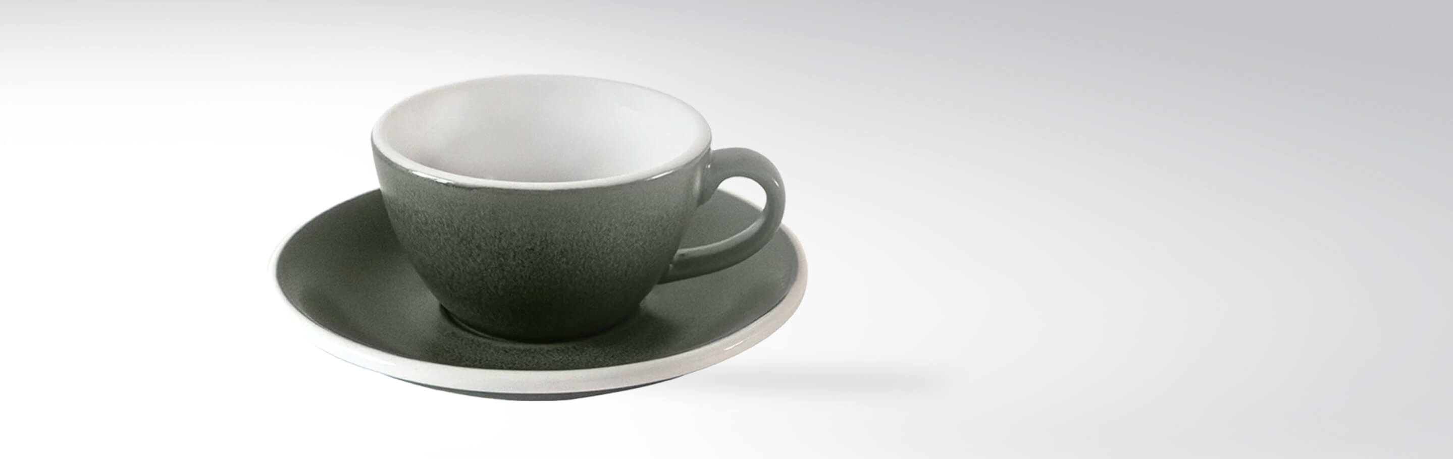 Graue Kaffeetasse mit passender Untertasse vor weißem Hintergrund