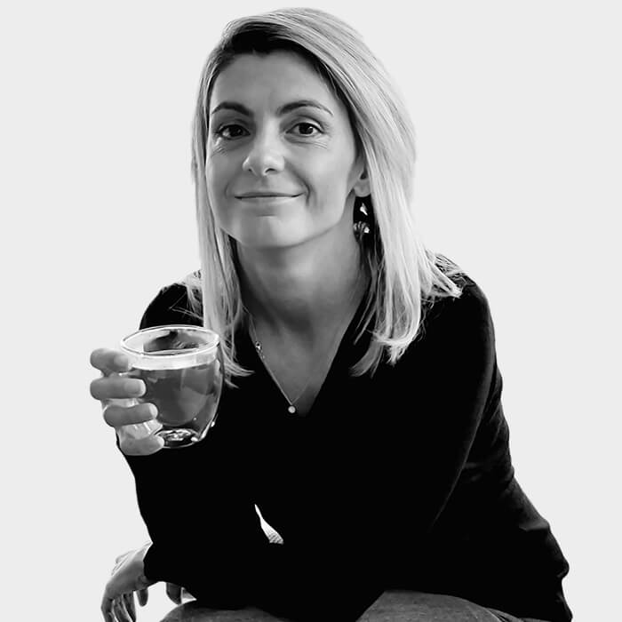 Frau genießt eine entspannende Tasse Tee Lächelnde Frau mit einer Tasse Tee in der Hand