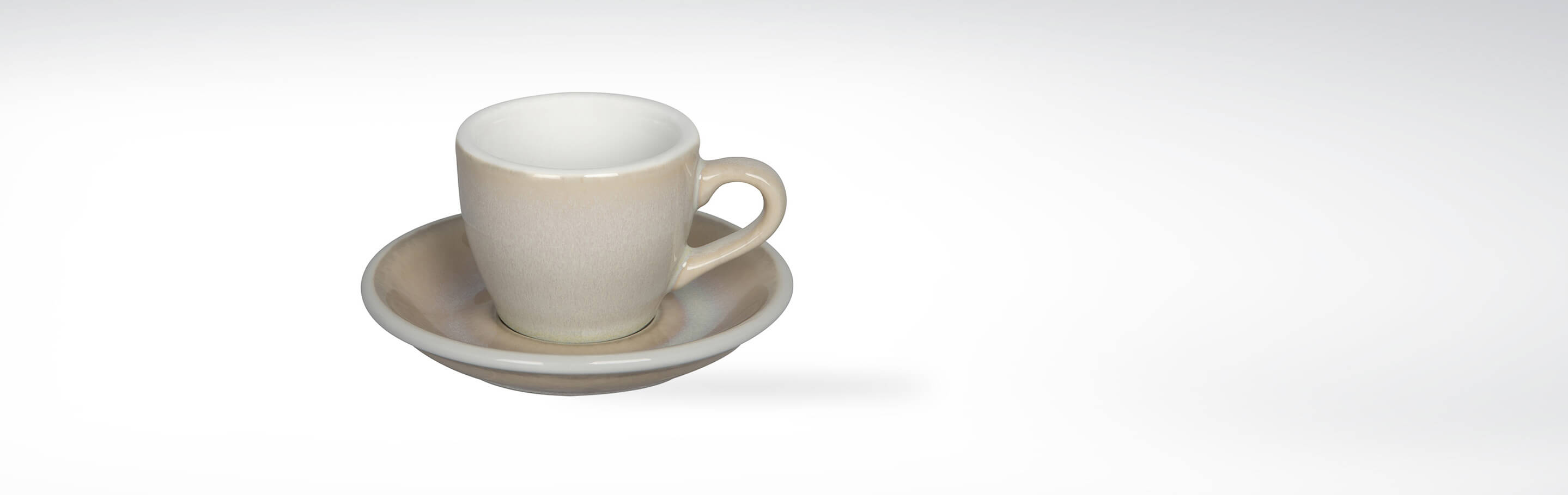 Keramische Espressotasse mit passender Untertasse in neutralem Beige auf weißem Hintergrund