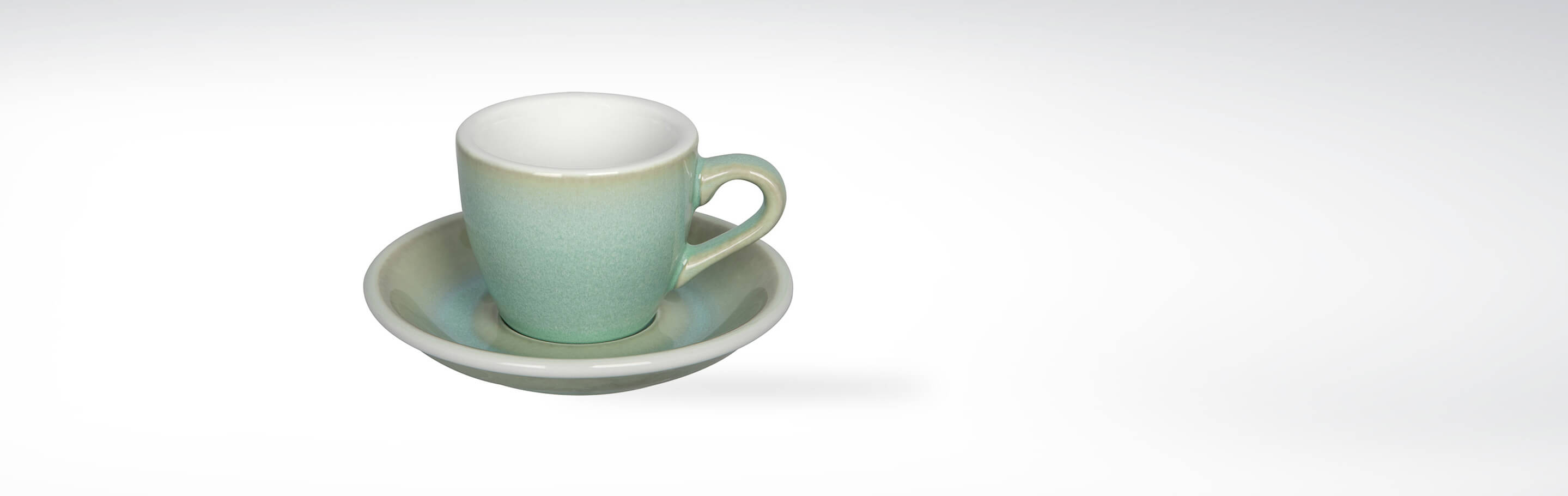 Minimalistische Espressotasse mit schlichter Untertasse, pastellgrün gefärbt