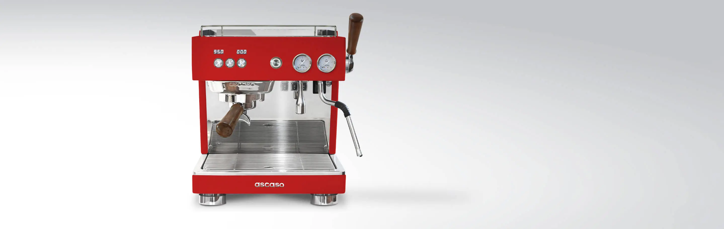 Frontansicht einer roten Ascaso Espressomaschine mit Holzgriffen und zwei Manometern vor einem grauen Hintergrund.