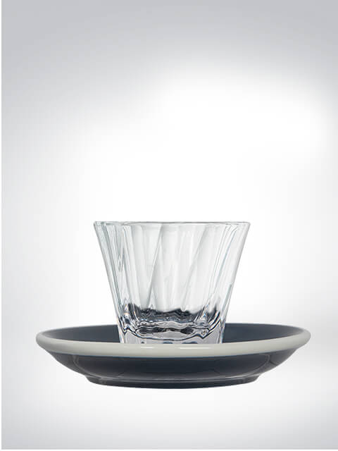 Ein stilvolles Trinkglas auf einer passenden Untertasse.