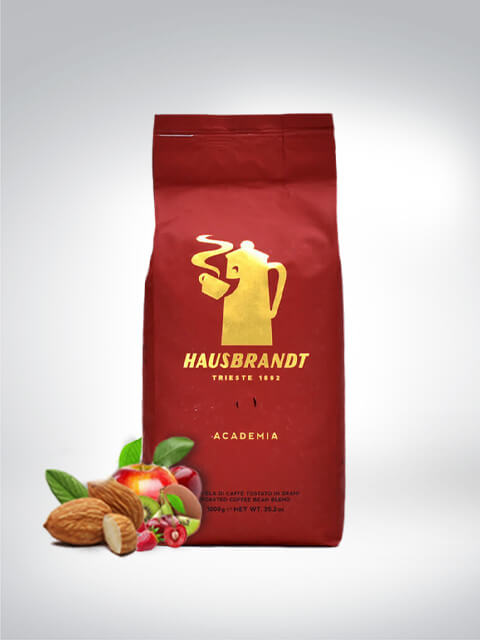 Eine rote Packung Hausbrandt Academia Kaffee mit Kaffeebohnen, frischen Mandeln und roten Beeren im Vordergrund