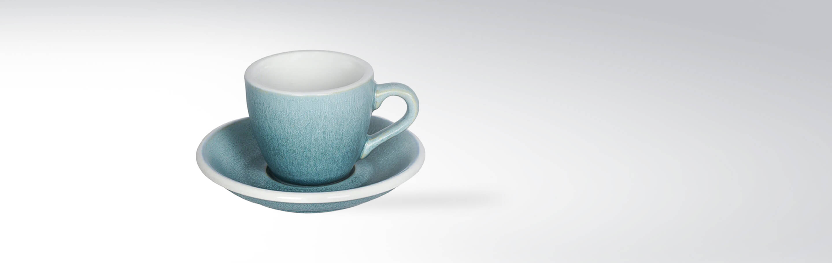 Blaue Espressotasse mit passender Untertasse auf weißem Hintergrund