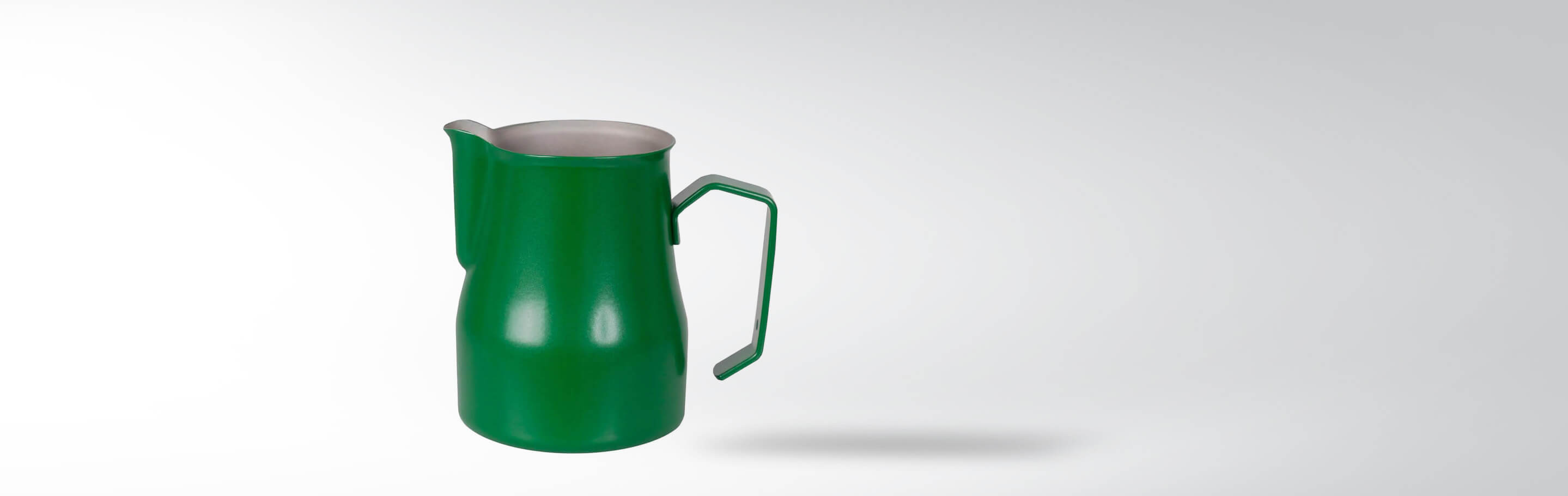 Grünes Milchkännchen aus Edelstahl mit Griff auf grauem Hintergrund