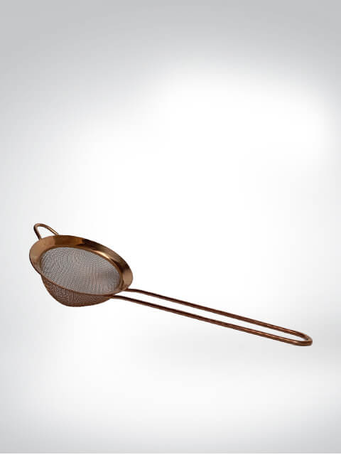 Ein Teesieb aus Edelstahl mit langem Griff und feinem Netz in schicker Kupferoptik, ideal zum Aufbrühen von losem Tee