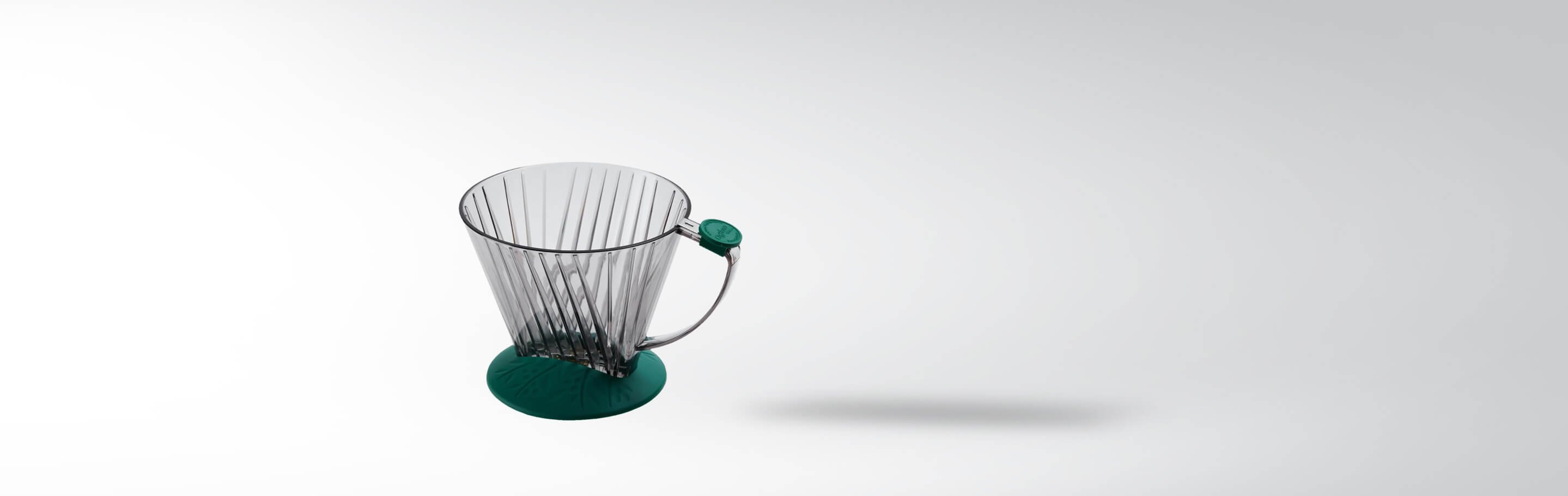 Kaffeefilterhalter mit transparentem Gehäuse und grünem Sockel auf weißem Hintergrund