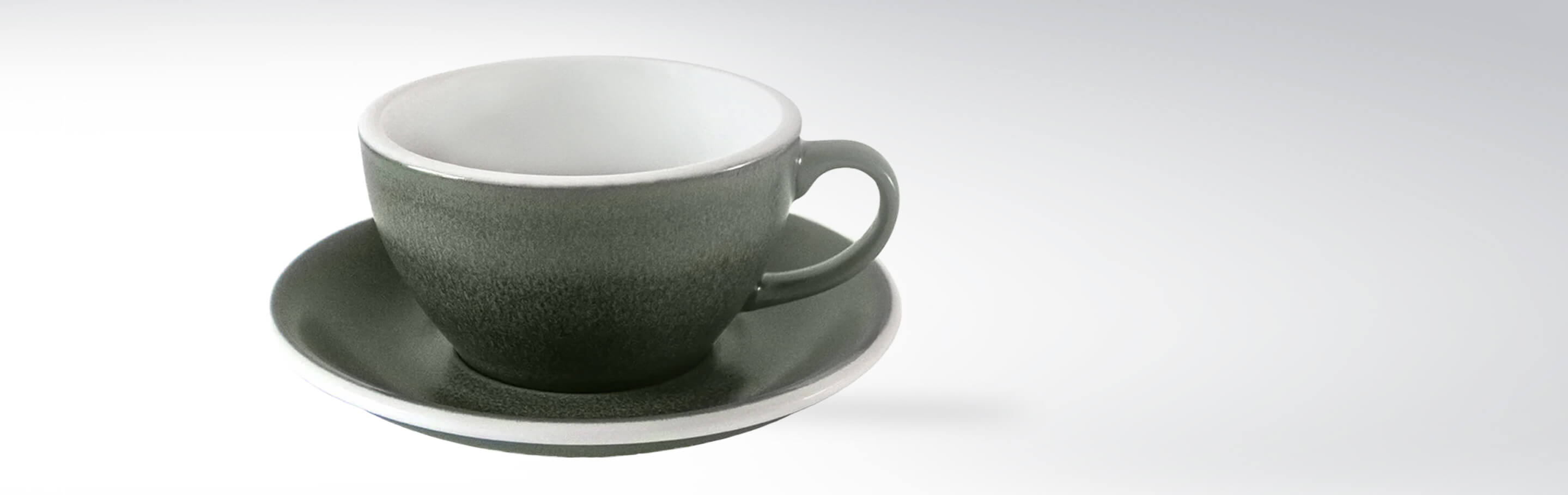 Eine elegante graue Kaffeetasse mit passender Untertasse aus Keramik vor hellem Hintergrund