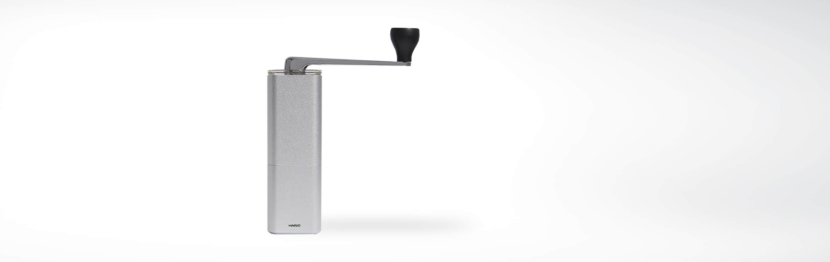 Manuelle Kaffeemühle aus Edelstahl mit Kurbel auf weißem Hintergrund