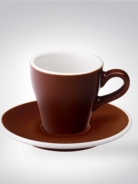 Braune Espressotasse mit passender Untertasse vor grauem Hintergrund