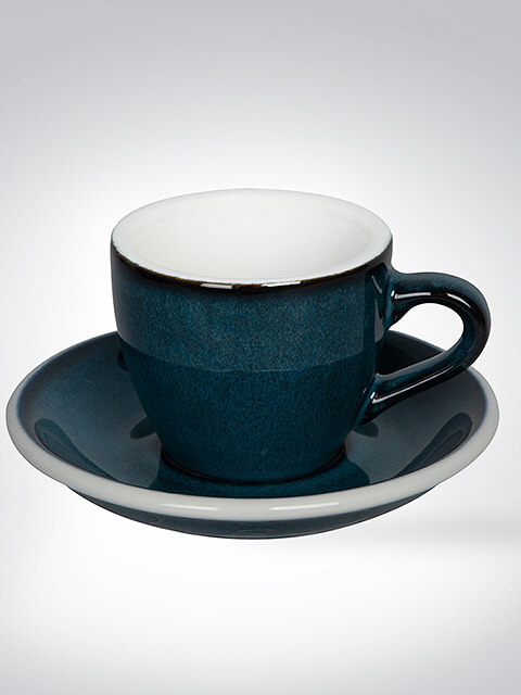 Eine dunkelblaue Tasse mit passender Untertasse auf einem hellen Hintergrund