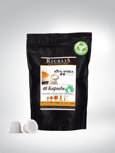 Packung Ricklis Kaffeerösterei Royal Arabica mit 40 Kapseln, umgeben von Kaffeekapseln. Hochwertiger Arabica-Kaffee für Kapselmaschinen.