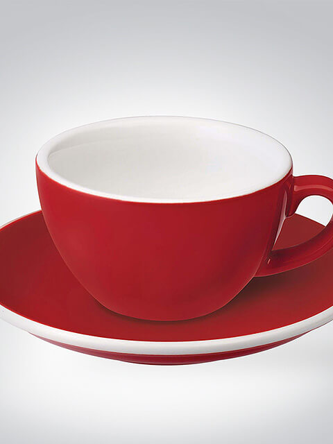 Rote Kaffeetasse mit weißem Innenraum, präsentiert auf passender roter Untertasse