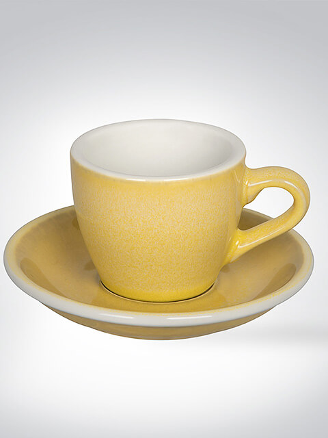 Gelbe Keramik-Espressotasse mit passender Untertasse auf hellem Hintergrund