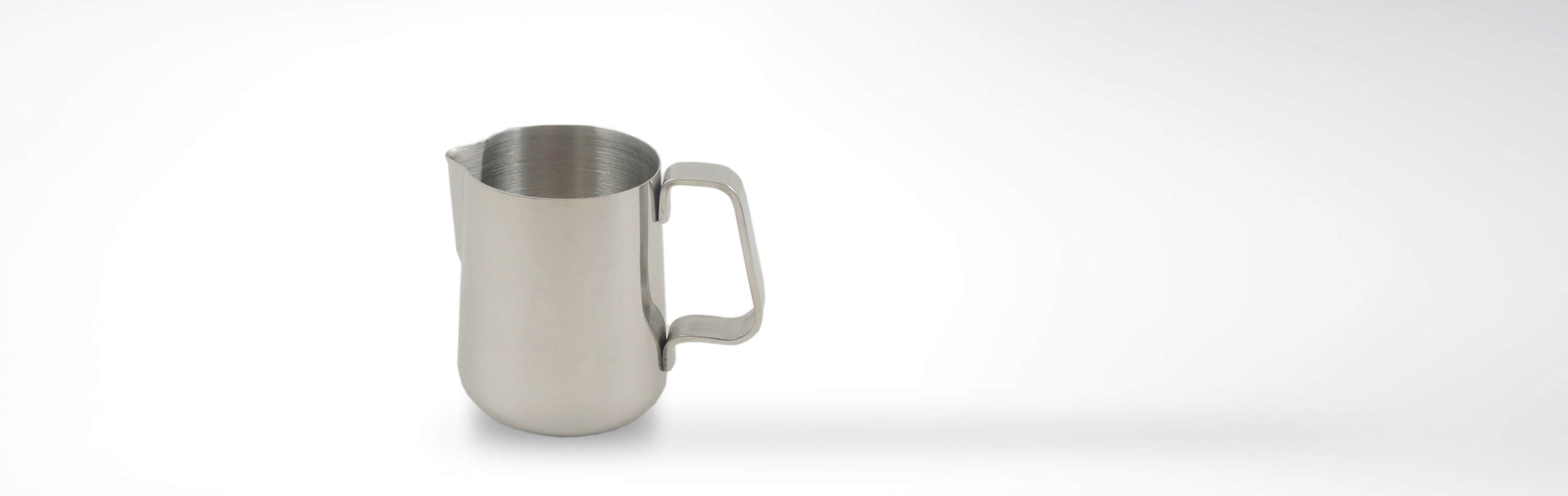 Edelstahl Milchkännchen mit Griff für die Kaffeezubereitung auf weißem Hintergrund