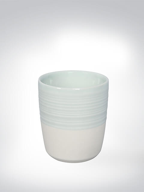 Ein eleganter Keramik-Becher in Pastellfarben. Der obere Teil des Bechers ist leicht geriffelt, während der untere glatt ist.