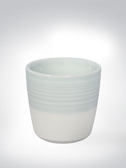 Ein weiß-blauer Keramikbecher mit dezentem Streifenmuster