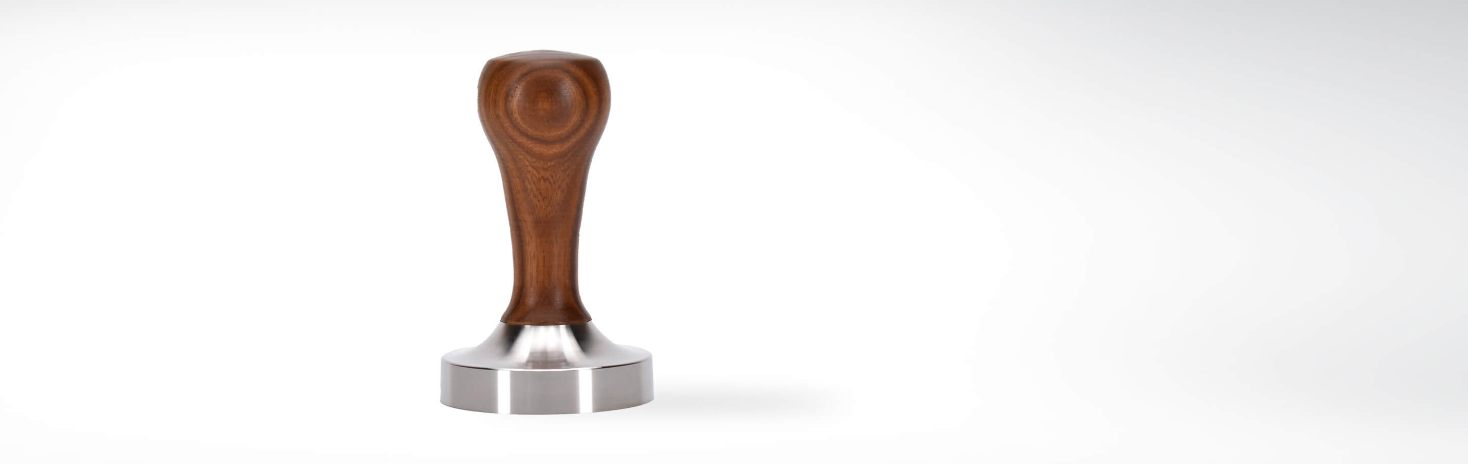 Espresso Tamper aus Edelstahl mit ergonomischem Holzgriff auf weißem Hintergrund