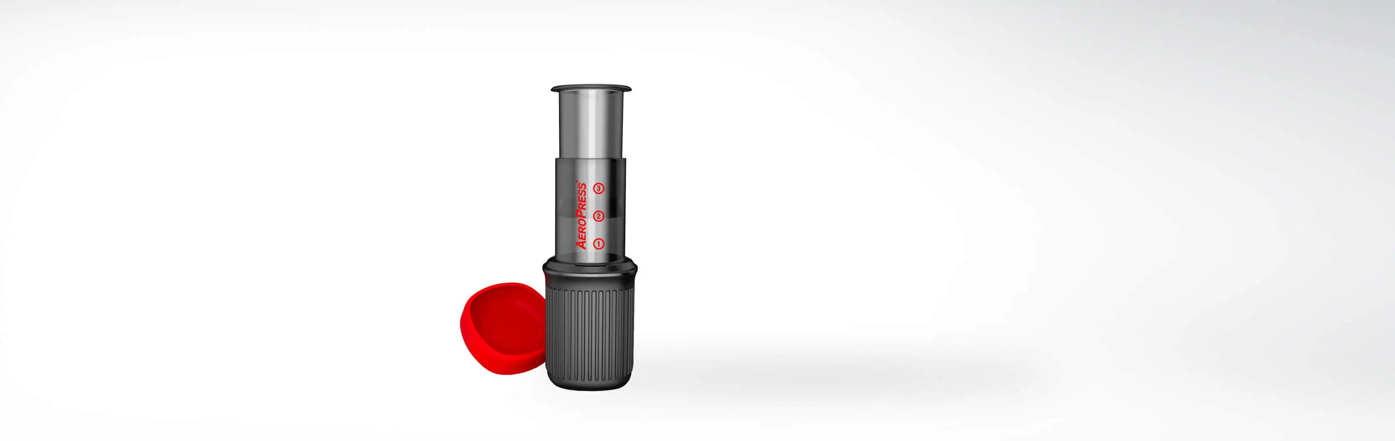 Bild einer Aeropress Kaffeemaschine mit abgenommenem rotem Deckel auf weißem Hintergrund