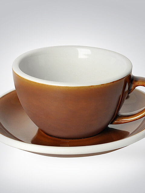 Nahaufnahme einer eleganten braunen Kaffeetasse mit passender Untertasse aus Keramik auf weißem Hintergrund