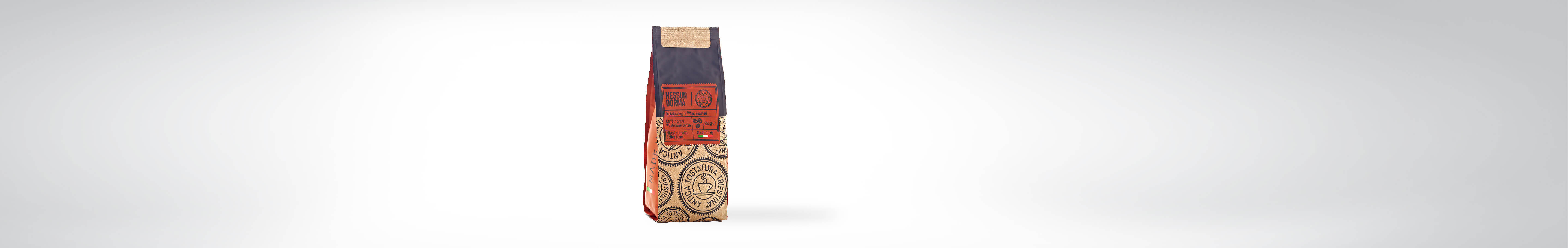 Eine Kaffeeverpackung mit einem traditionellen, rot-beigen Design und einem Etikett, das auf die Herkunft und Qualität des Kaffees hinweist, auf einem neutralen Hintergrund.