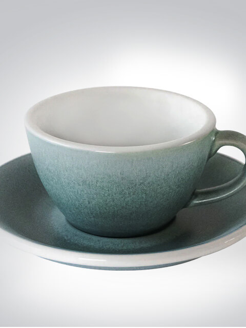 Kaffeetasse mit grünem Farbverlauf und passender Untertasse